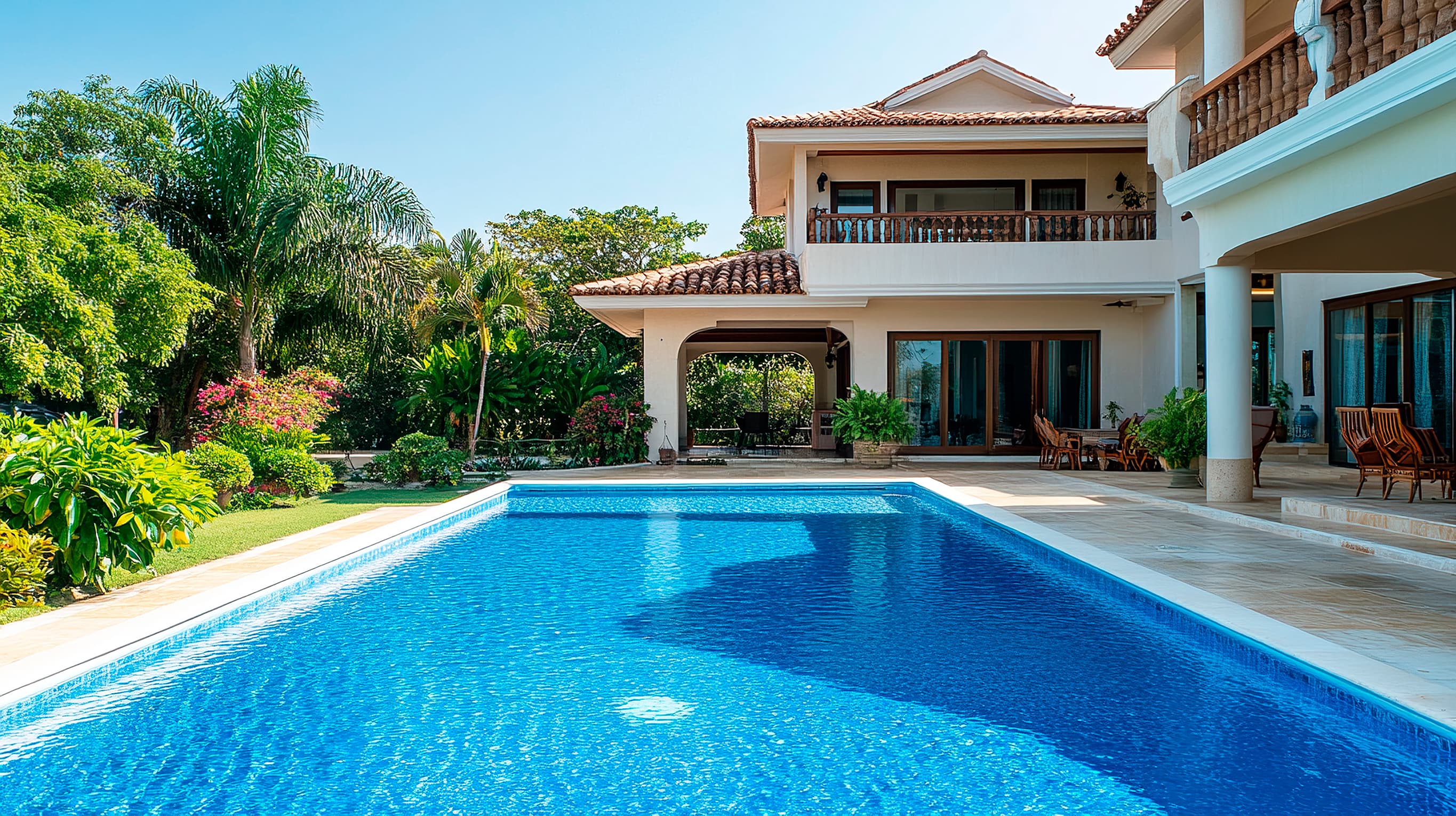 Piscina com casa e árvores ao fundo